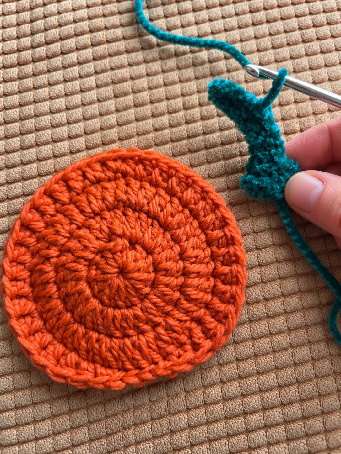 Green stem crochet beside orange coaster 6